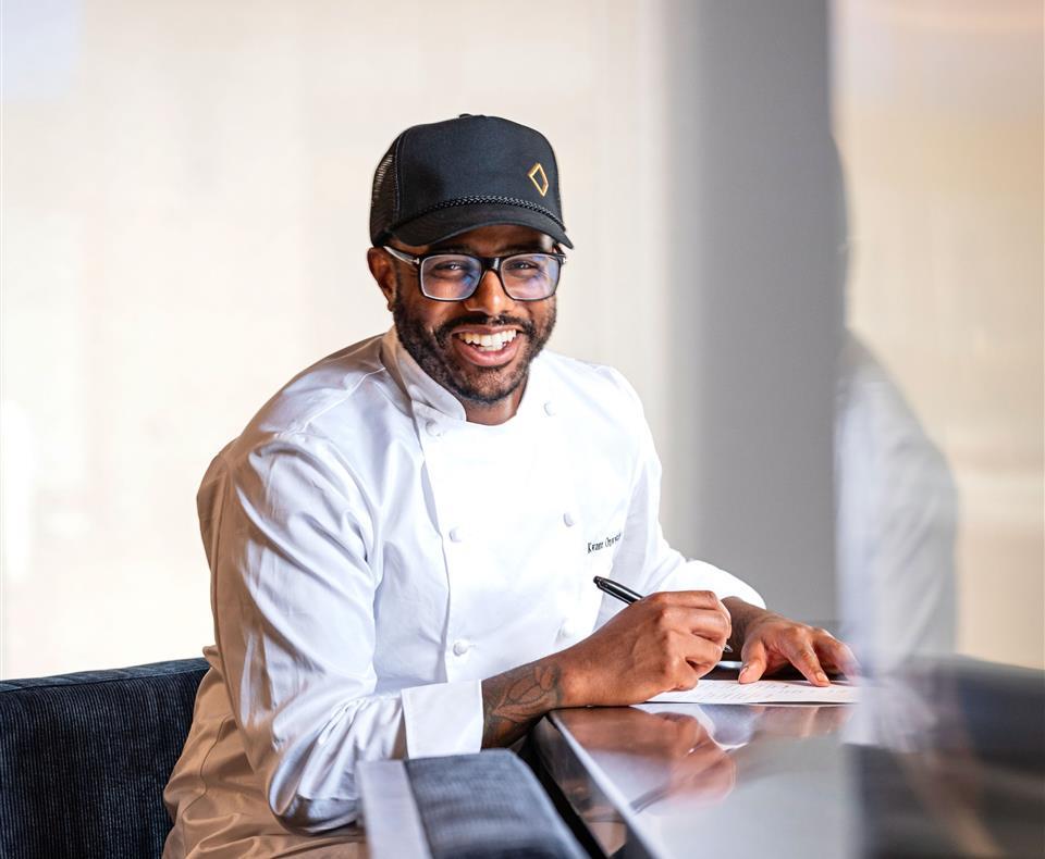 chef kwame onwuachi sitting at Dogon